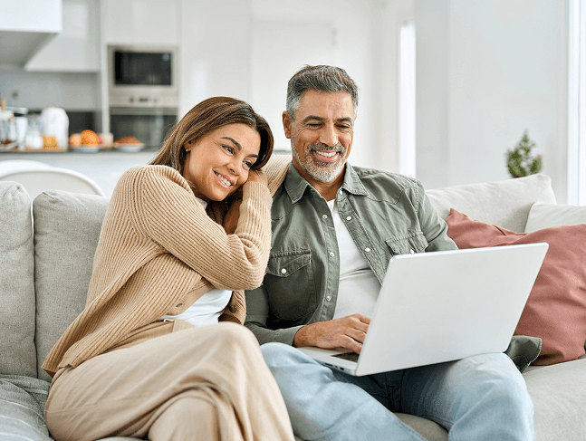 Happy couple working together on estate planning from their comfortable home